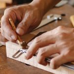 hands measuring wood